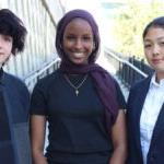 The three student board members pose for a photo outside.